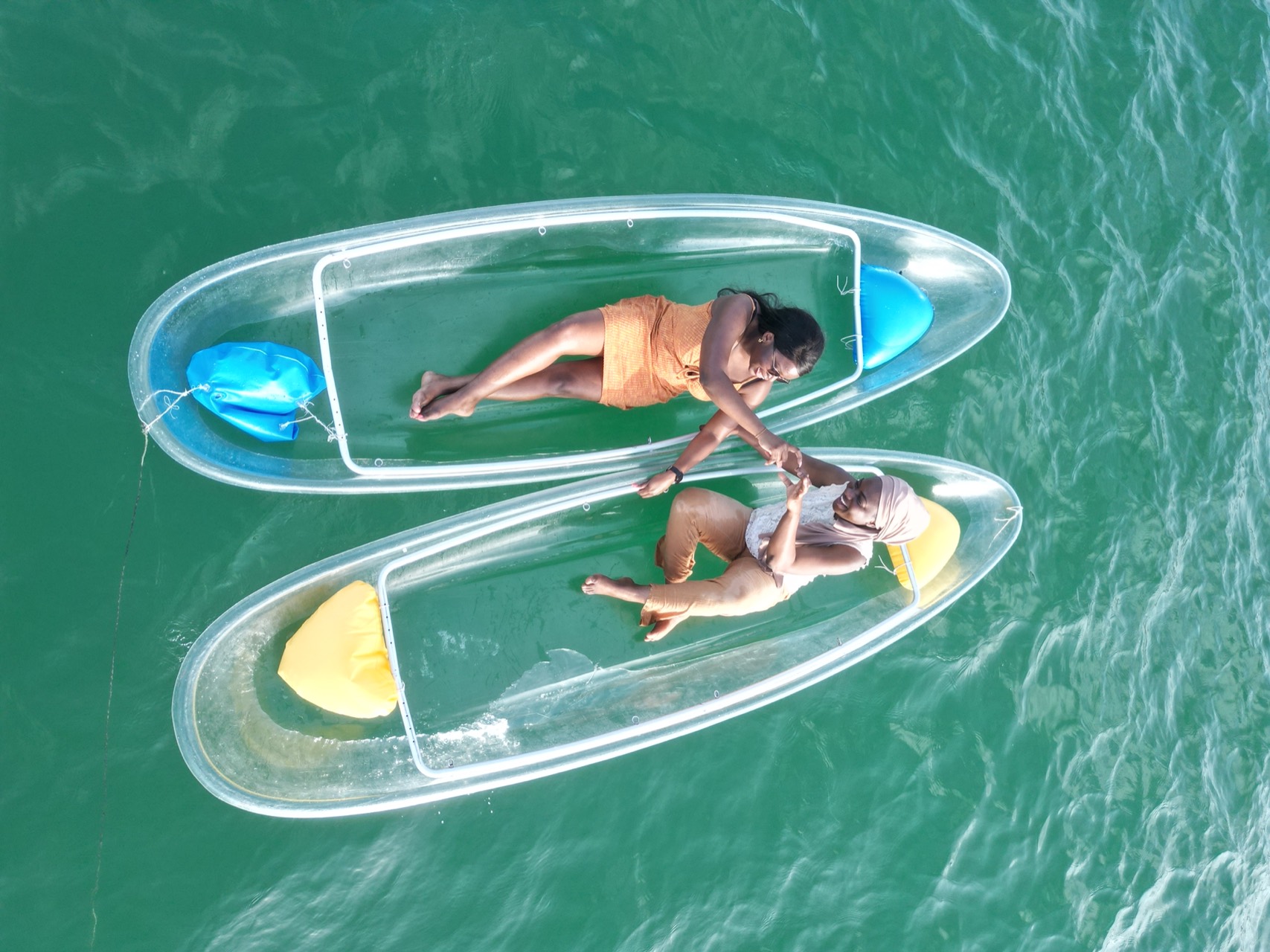 Couple côte à côte dans deux kayaks transparents sur l’eau turquoise de Ngor - Kayak en couple Dakar, Senegal Nautique