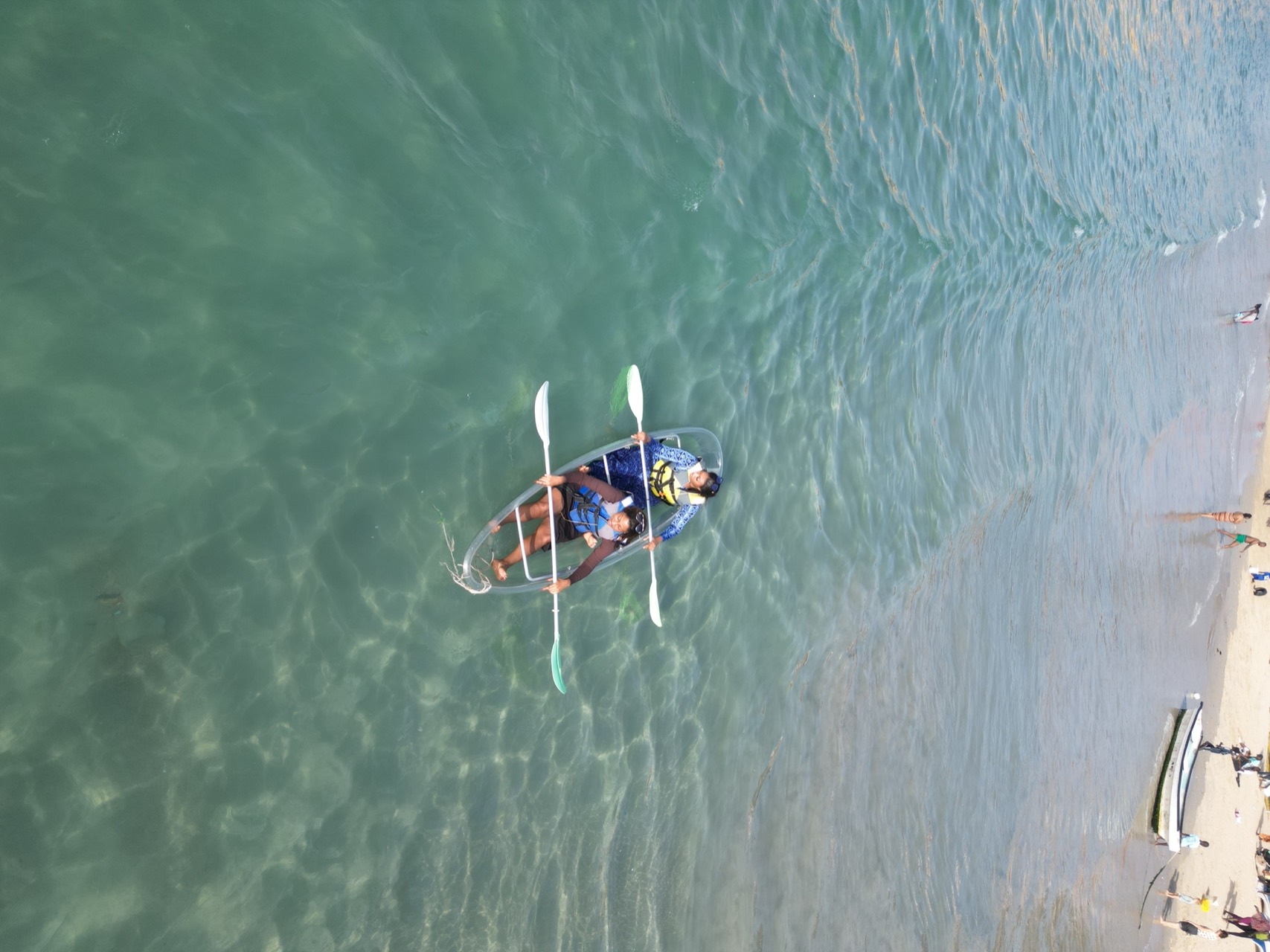 Deux enfants en gilet de sauvetage dans un kayak transparent duo à Ngor