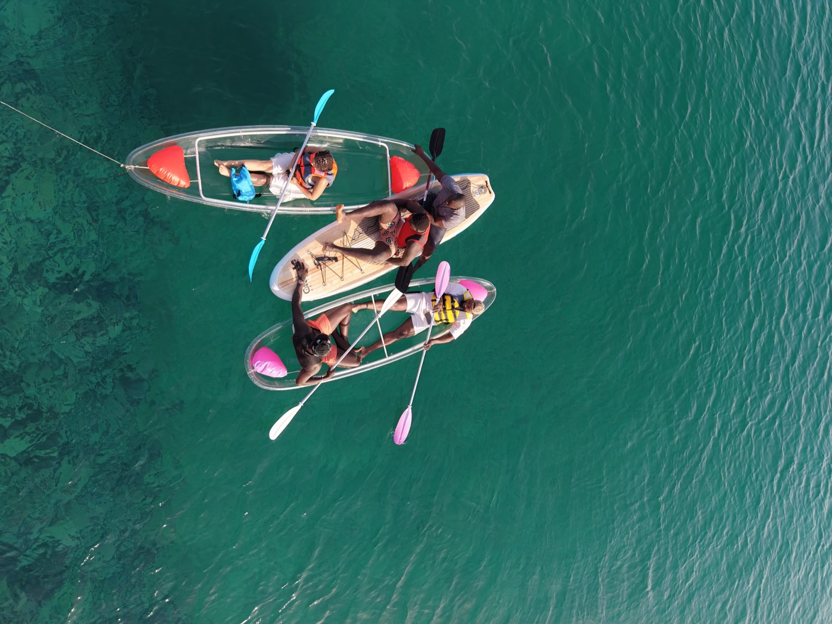 Famille en kayaks transparents et sur une planche de paddle à Ouakam