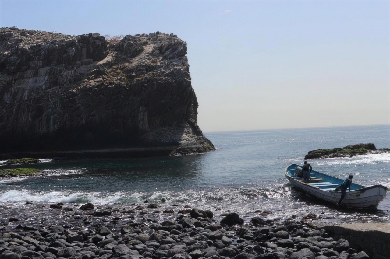 Pebble beach and pirogue below the cliffs of the Île des Madeleines - Île des Madeleines Dakar, Senegal Nautique