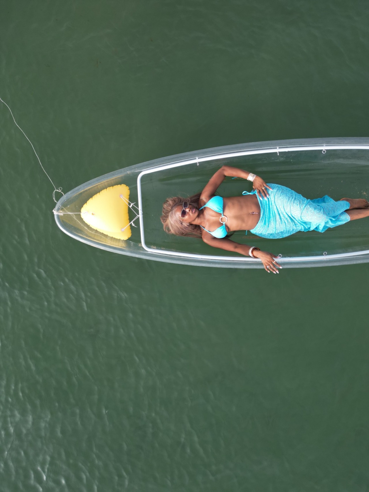 Drone photoshoot of a client in a turquoise swimsuit in a clear kayak in Dakar - Drone photoshoot Almadies, Senegal Nautique
